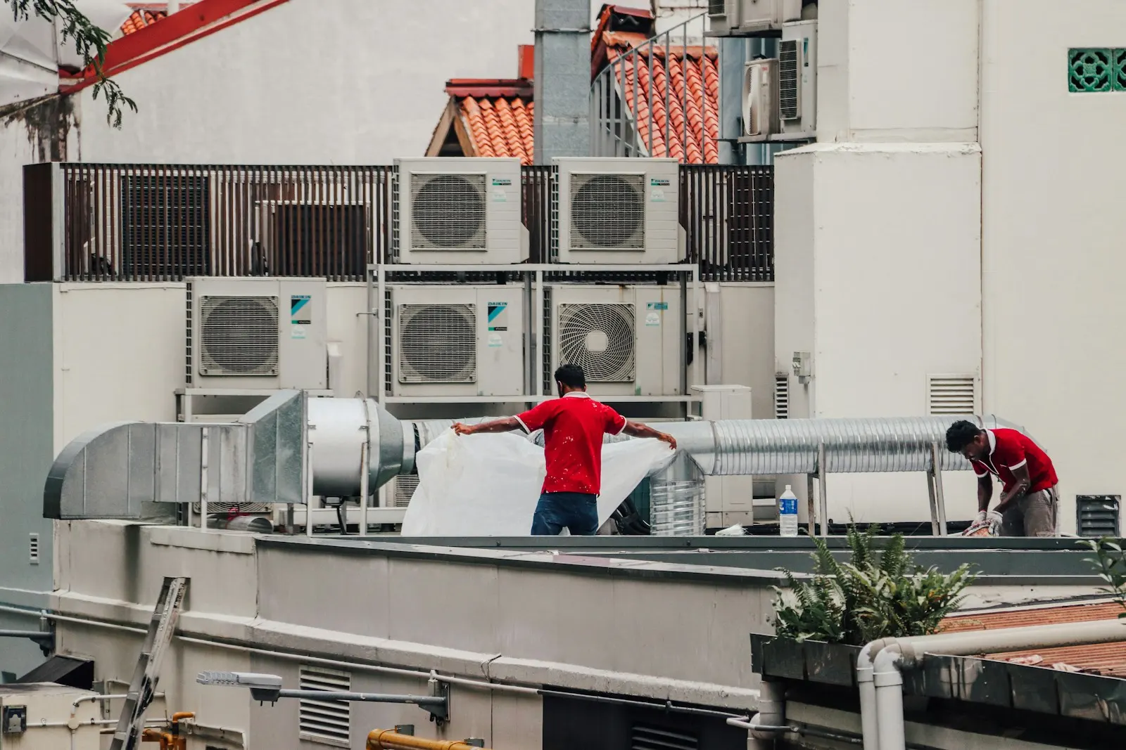 Technicians servicing rooftop air conditioning units